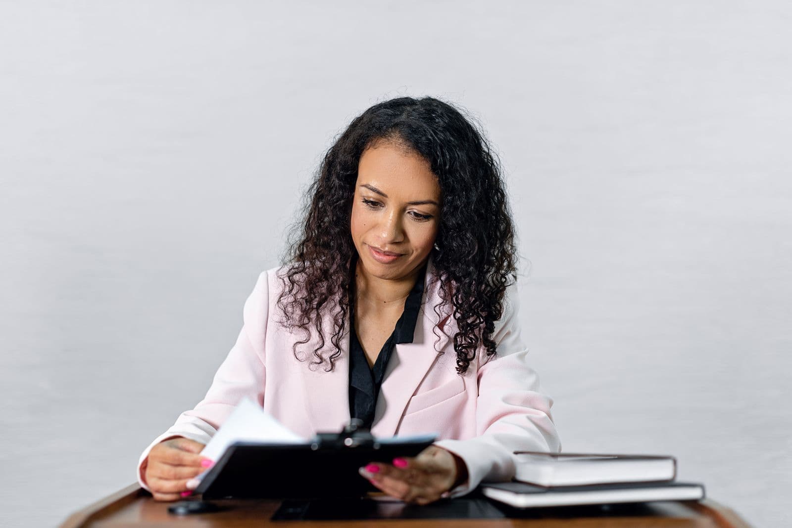 A businesswoman confidently reviewing documents at her desk.